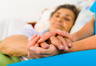 A caregiver held the hands of her patient